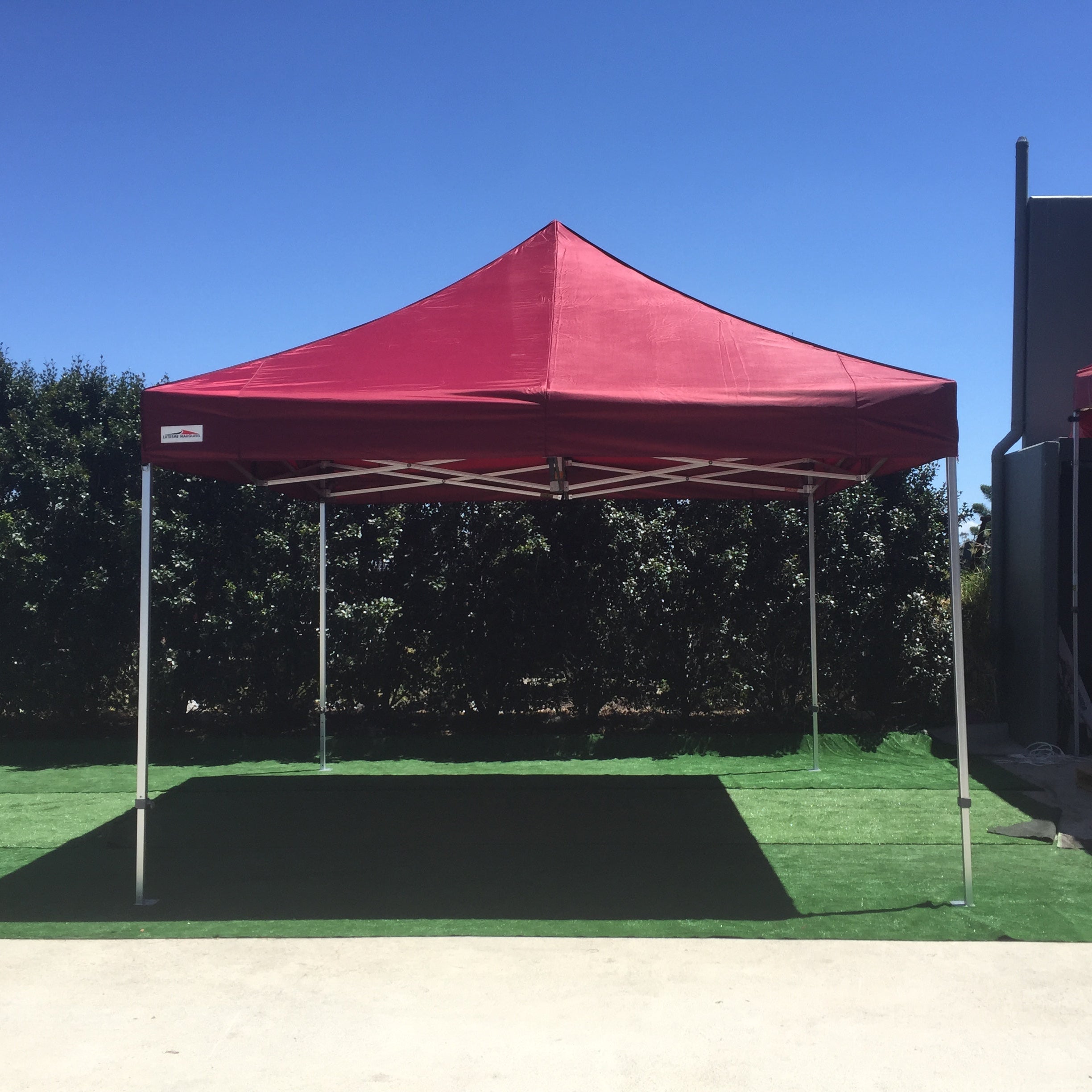 Maroon 4x4m pop-up canopy tent set up outdoors