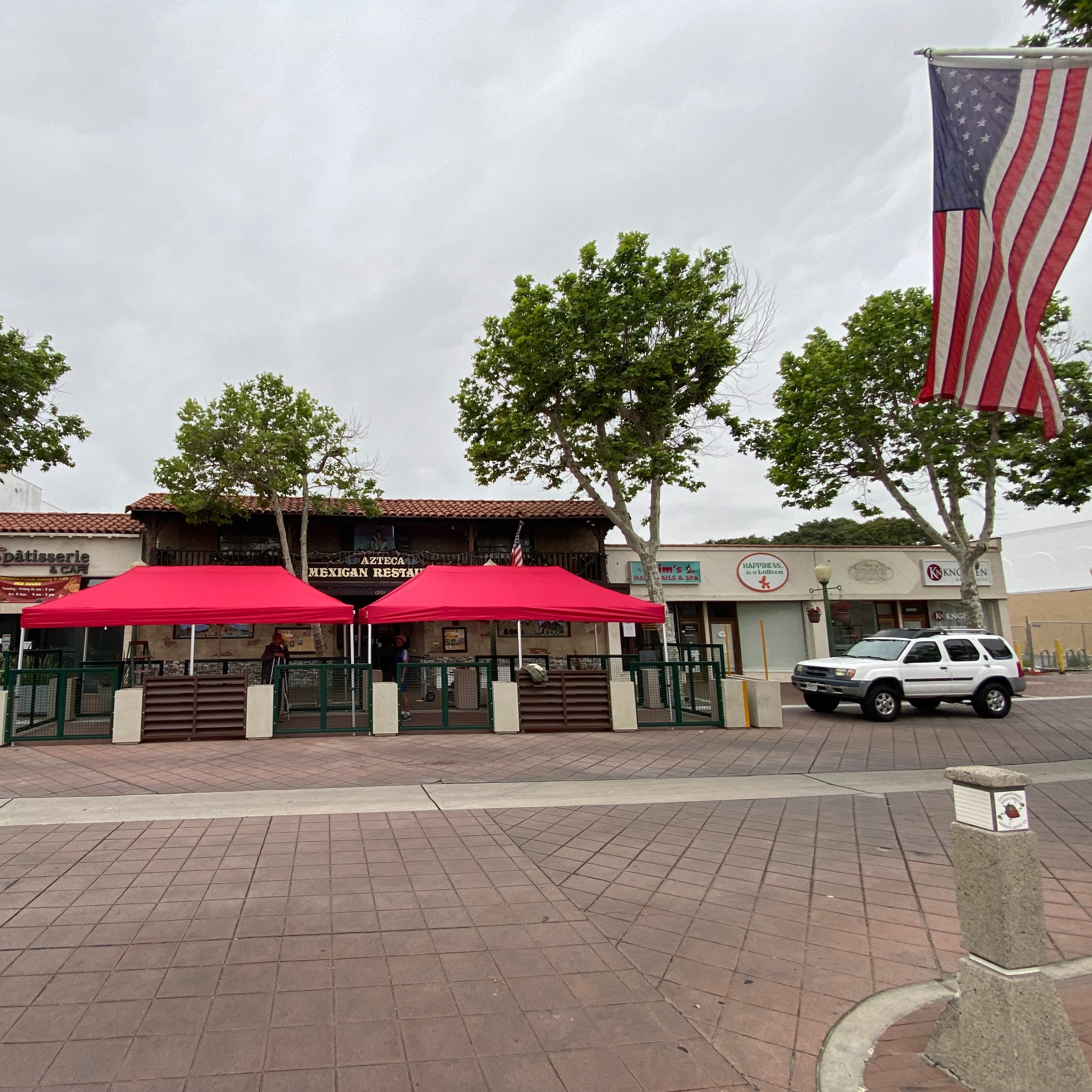 Red canopy tents set up outside Azteca Mexican Restaurant
