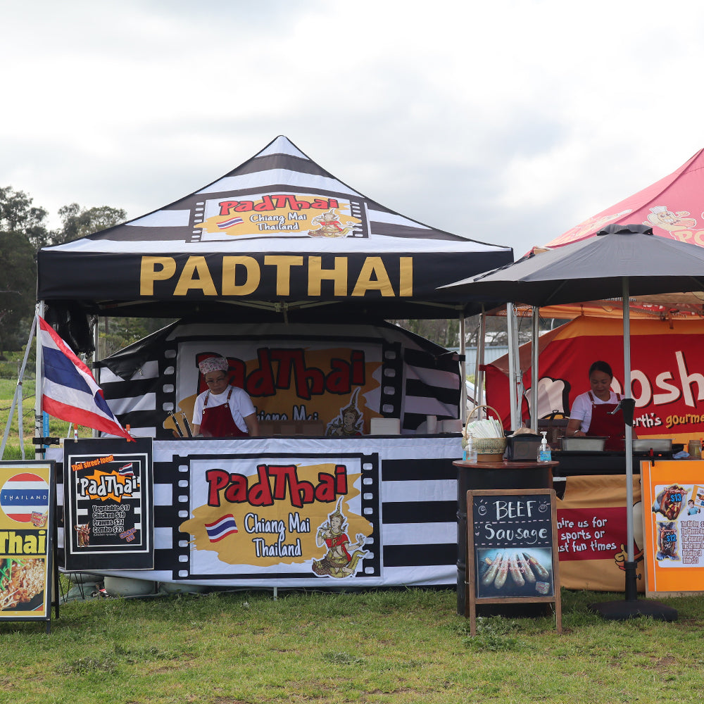 canopy tent set up with custom-printed half wall featuring "Padthai" branding.