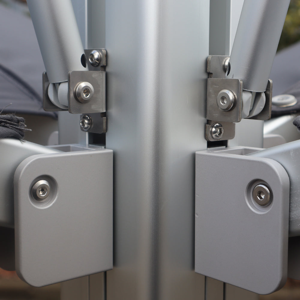 Multi-shade umbrella connector showing metal brackets, bolts, and support arms attached to the central pole.