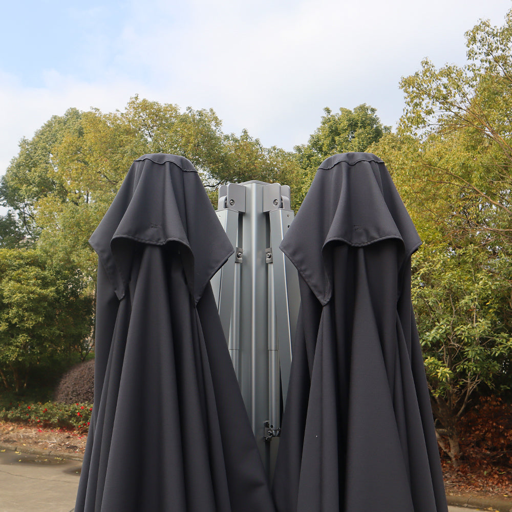 Multi-shade cantilever umbrella system in the closed position, showing folded dark gray canopies and the central support mechanism.