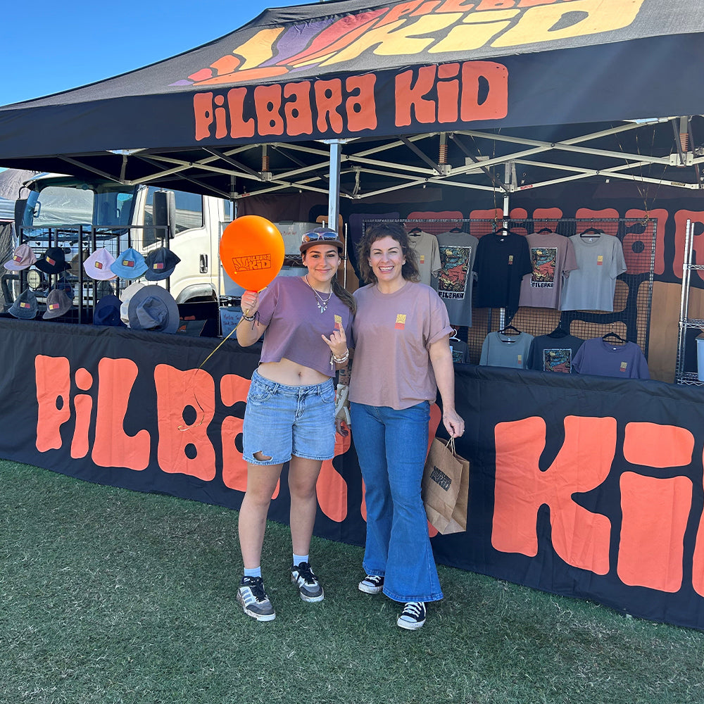 Black canopy booth with custom-printed half wall featuring bold "PILBARA KID" branding.